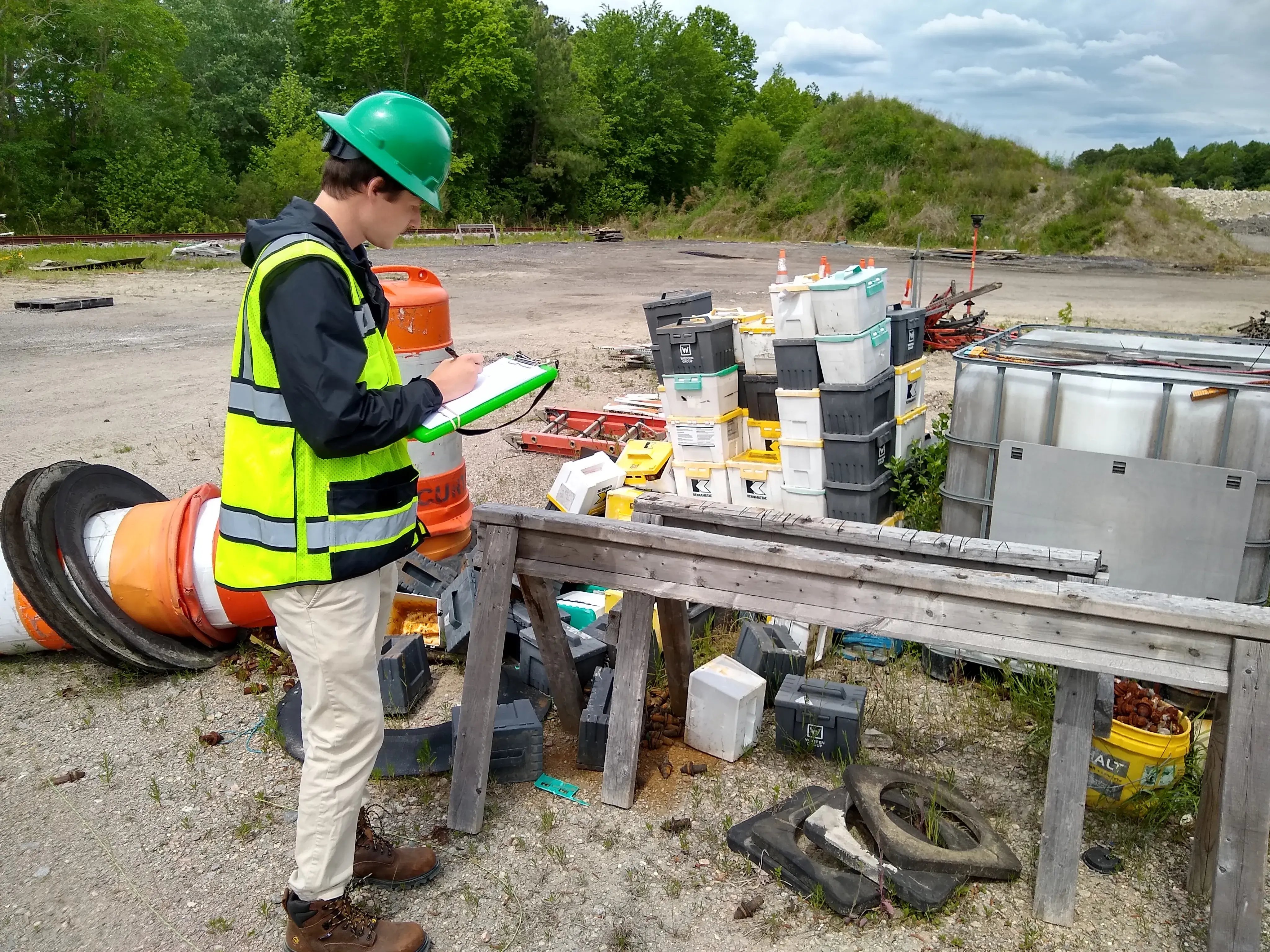 RMA environmental consultant inspecting waste materials during a Phase I ESA at an outdoor industrial site