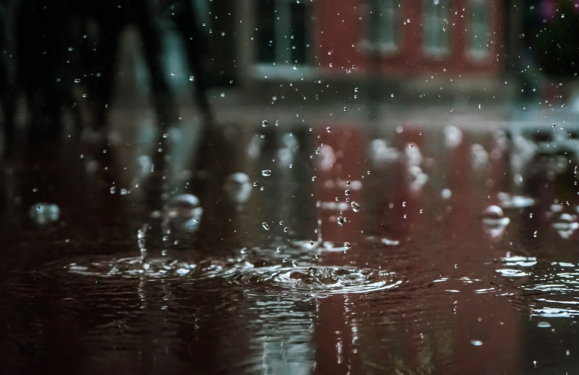 Dark Rain Drops Landing in a Puddle